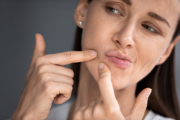 woman try to pop a blackhead