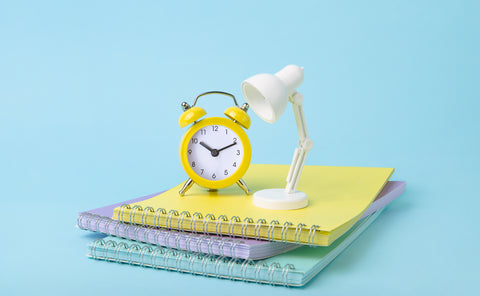 stack of notepads with clock and small light