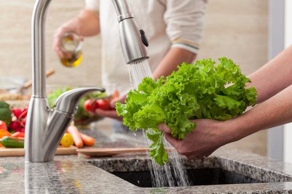 woman washing lettuce before making a salad