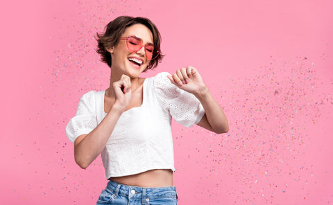 Woman celebrating with pink back drop