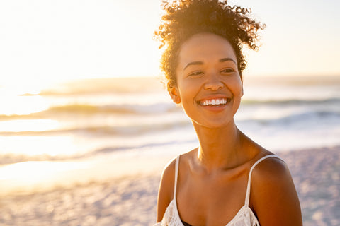 Young woman smiling in the sunset on the beach