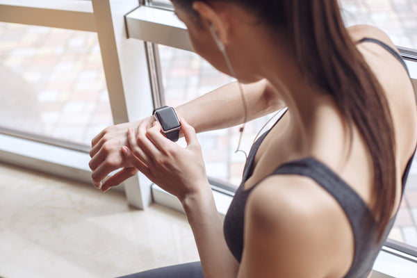 woman checking her watch to start her workout