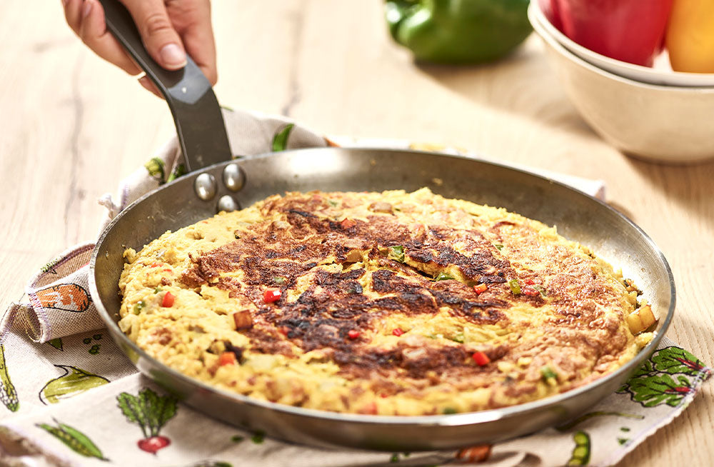 Tortilla de patatas y pimientos en sartén de hierro