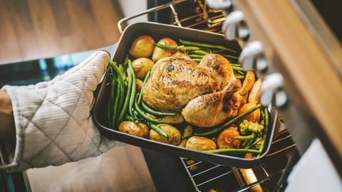 lady removing cooking dish from oven