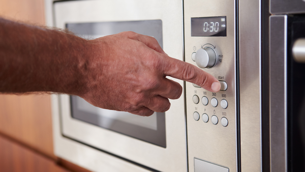 man operating a microwave oven