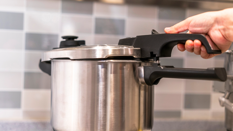 person opening a pressure cooker