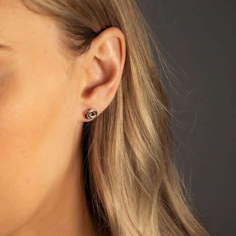 A model wears sterling silver interlocking circle stud earrings