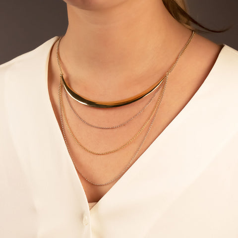 A model wears a statement necklace of sterling silver and gold vermeil chains of various lengths