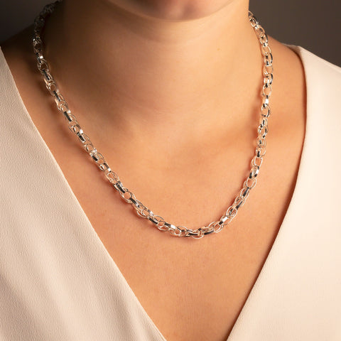 A silver linked necklace shown on the neck of a model