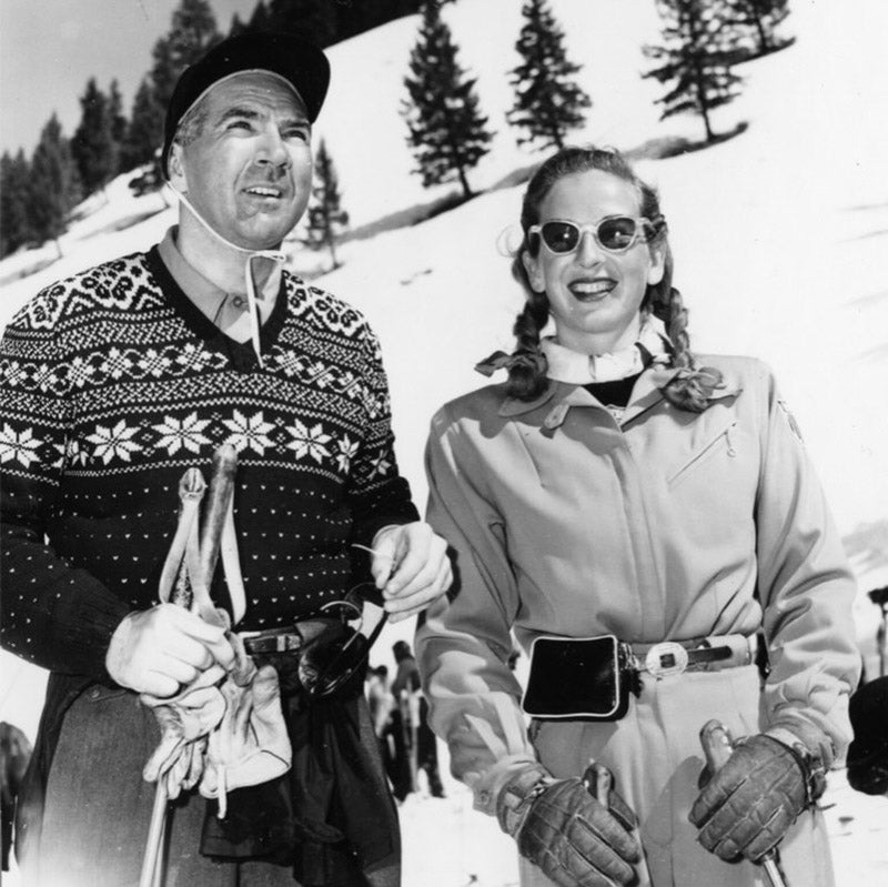 Donald and Gretchen Fraser standing side-by-side with the snowy mountain and line of trees in the backdrop.