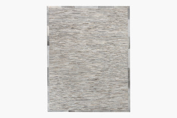 A Ladro Hide – Grey with a textured pattern in various shades of gray, featuring thin horizontal lines that give it a stone-like appearance. Part of the Ben Soleimani collection, this premium hair-on cowhide rug has a bordered design with a slightly darker gray trim around the edges.