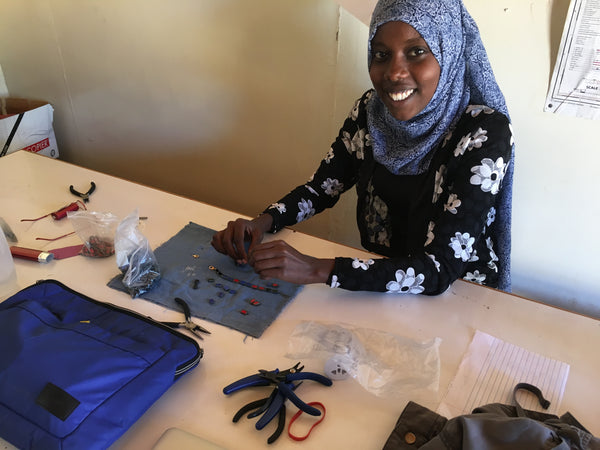 Leyla from Daraja Academy makes a bracelet