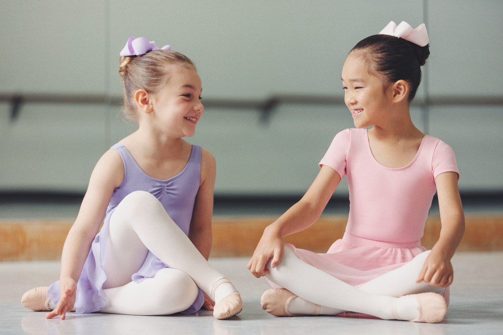 Two Girls Sat Giggling Wearing Bloch Ballet Outfits