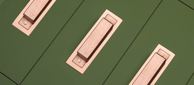 Copper handles on green drawers. handles online uk