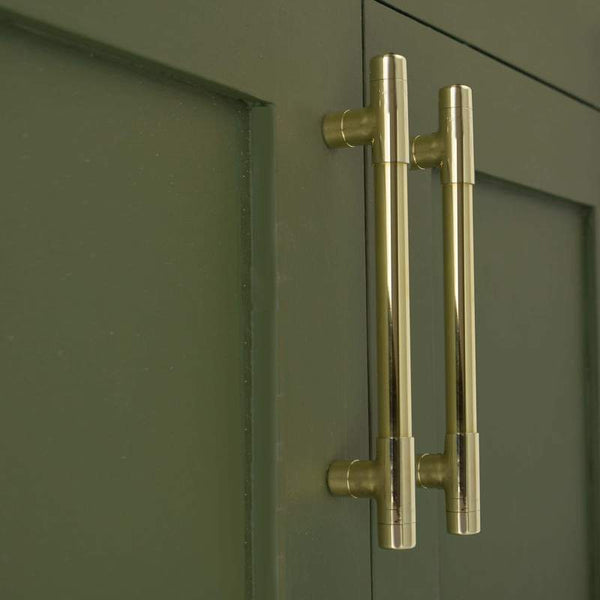 brass handles on green cabinets