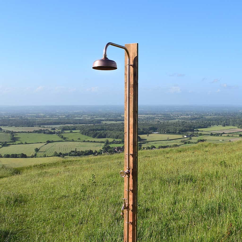 Brass shower outdoors photographed in the English countryside on a summers day