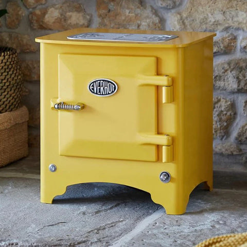 Everhot Electric stove in yellow infront of stone exposed wall