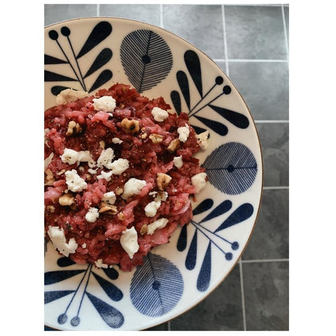 bowl of beetroot risotto with goats cheese and toasted walnuts