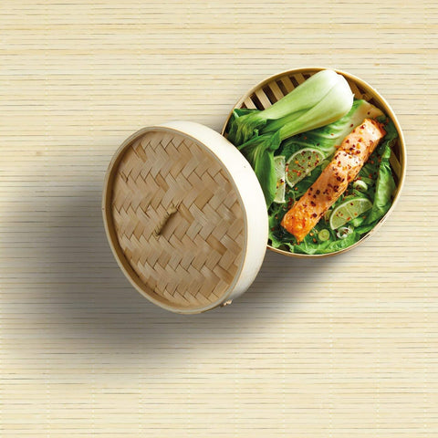 two tier bamboo steamer with vegetables and fish in top compartment