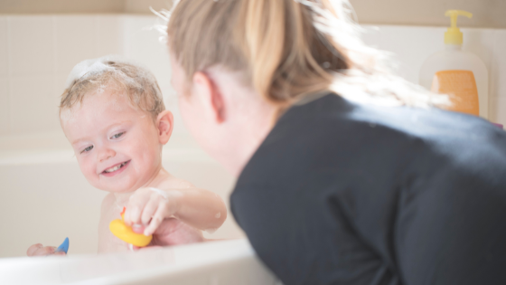 a mom washes her toddler in the bath as part of figuring out how to treat eczema without steroids