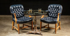 Vintage tufted leather chairs and antique cast iron table