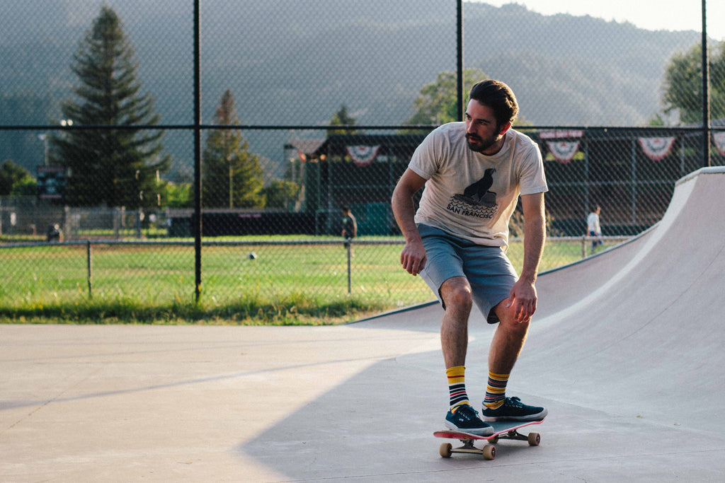 A guy wearing a san francisco sea lion shirt at a skatepark.