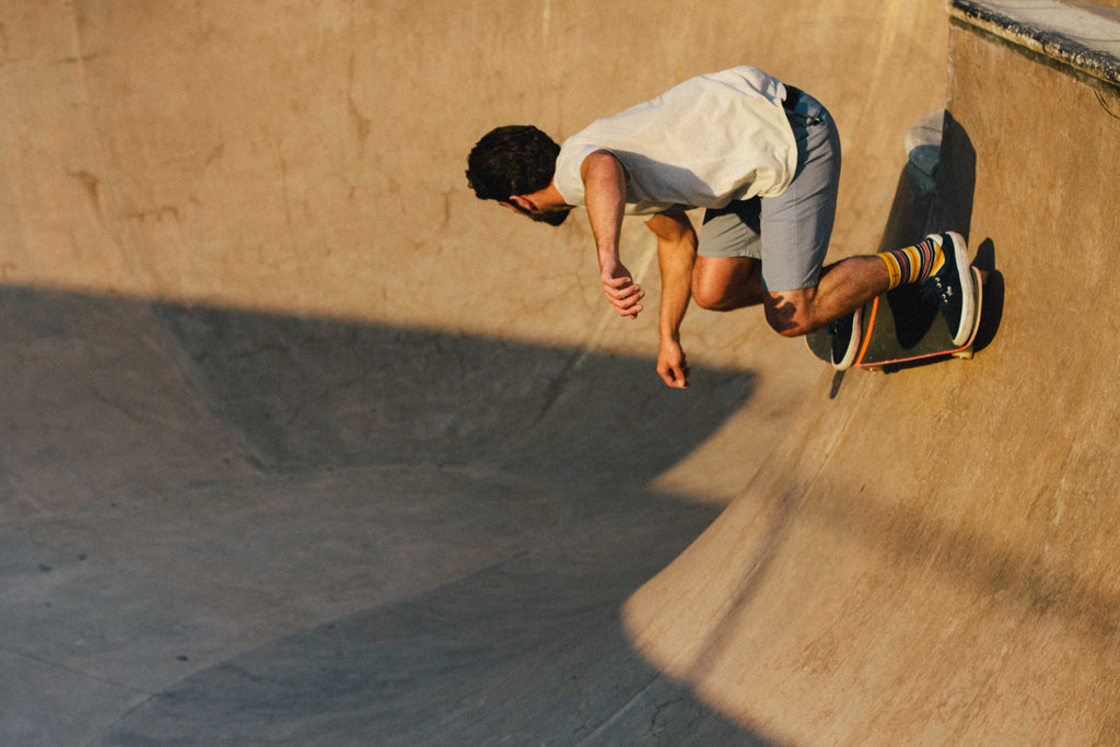 Skateboarder doing backside turn in a bowl.