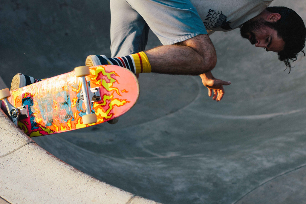 A skateboarder doing a backside pivot in a bowl.