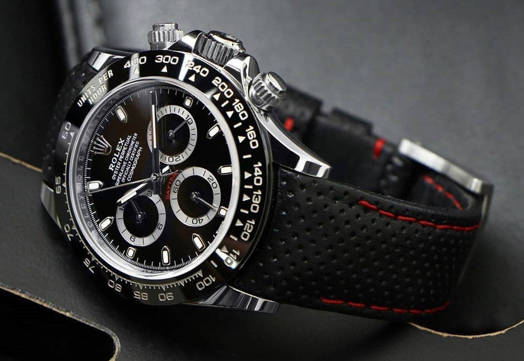 rolex daytona cosmograph watch on a black perforated leather strap