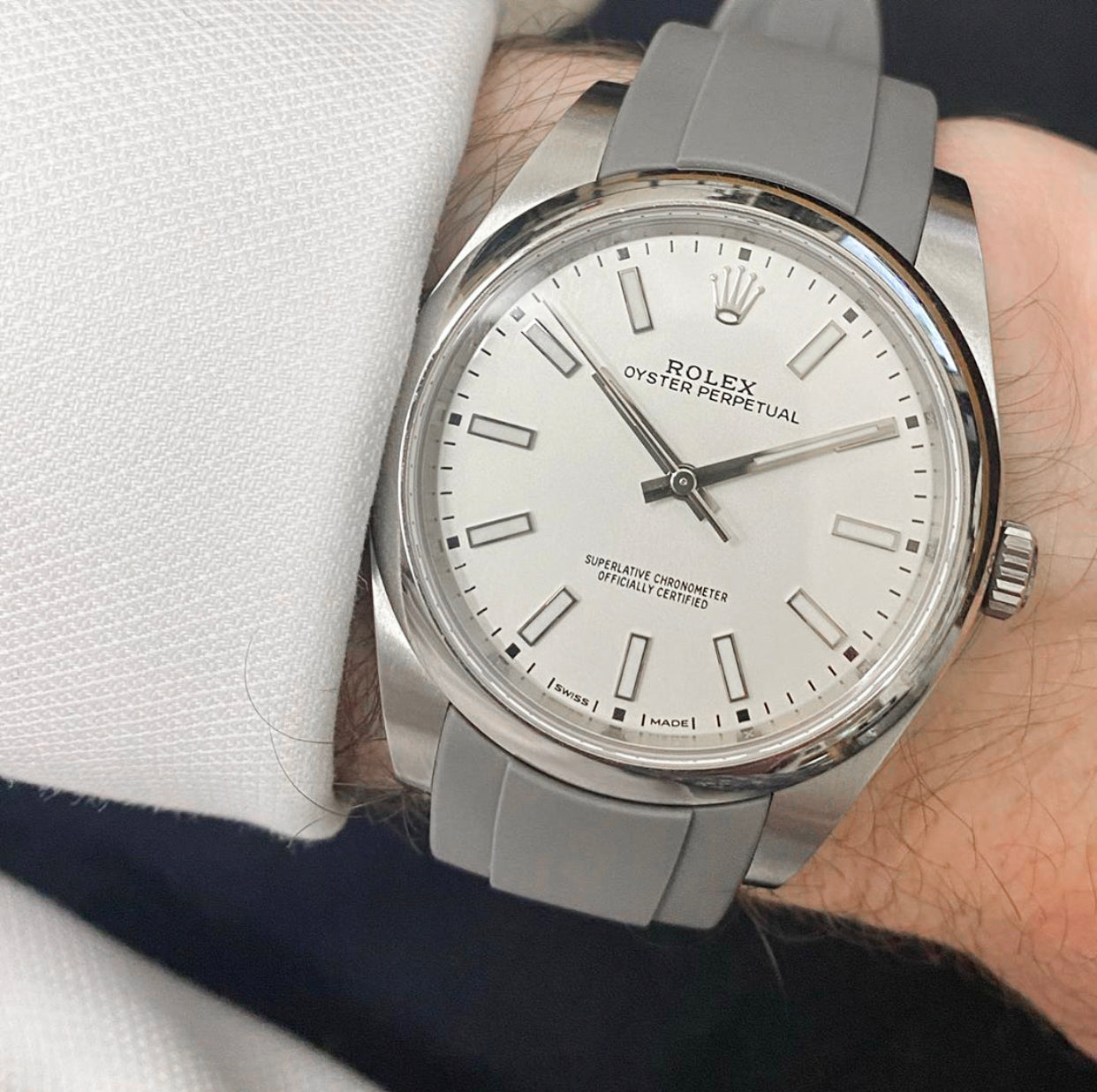 rolex oyster perpetual watch with white dial on a gray rubber strap