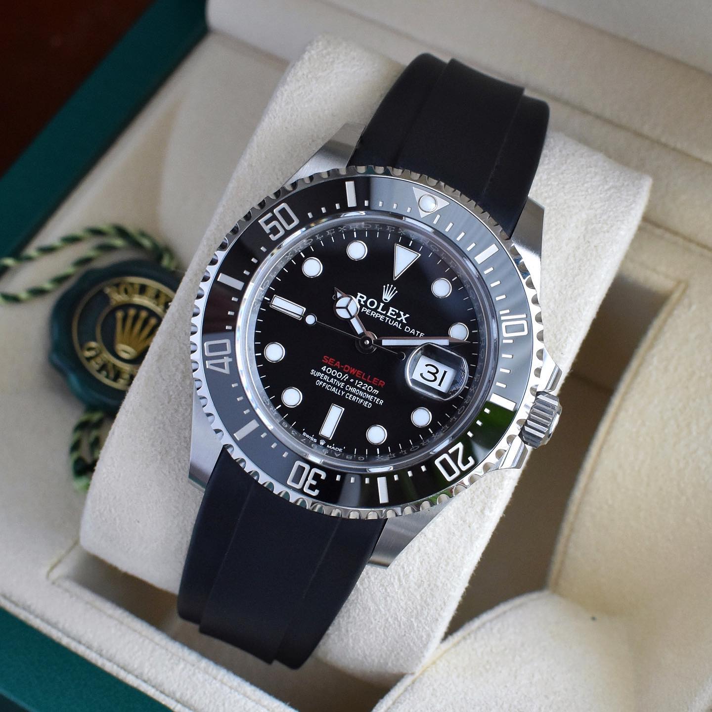 rolex sea-dweller watch on a black rubber watch strap sitting inside a rolex box