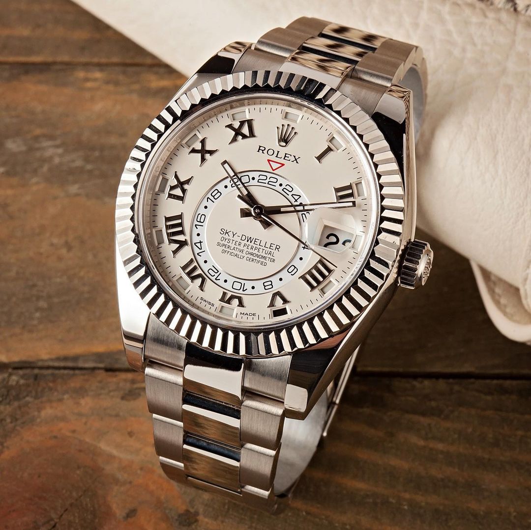 rolex sky-dweller watch with white dial and fluted bezel on a metal bracelet