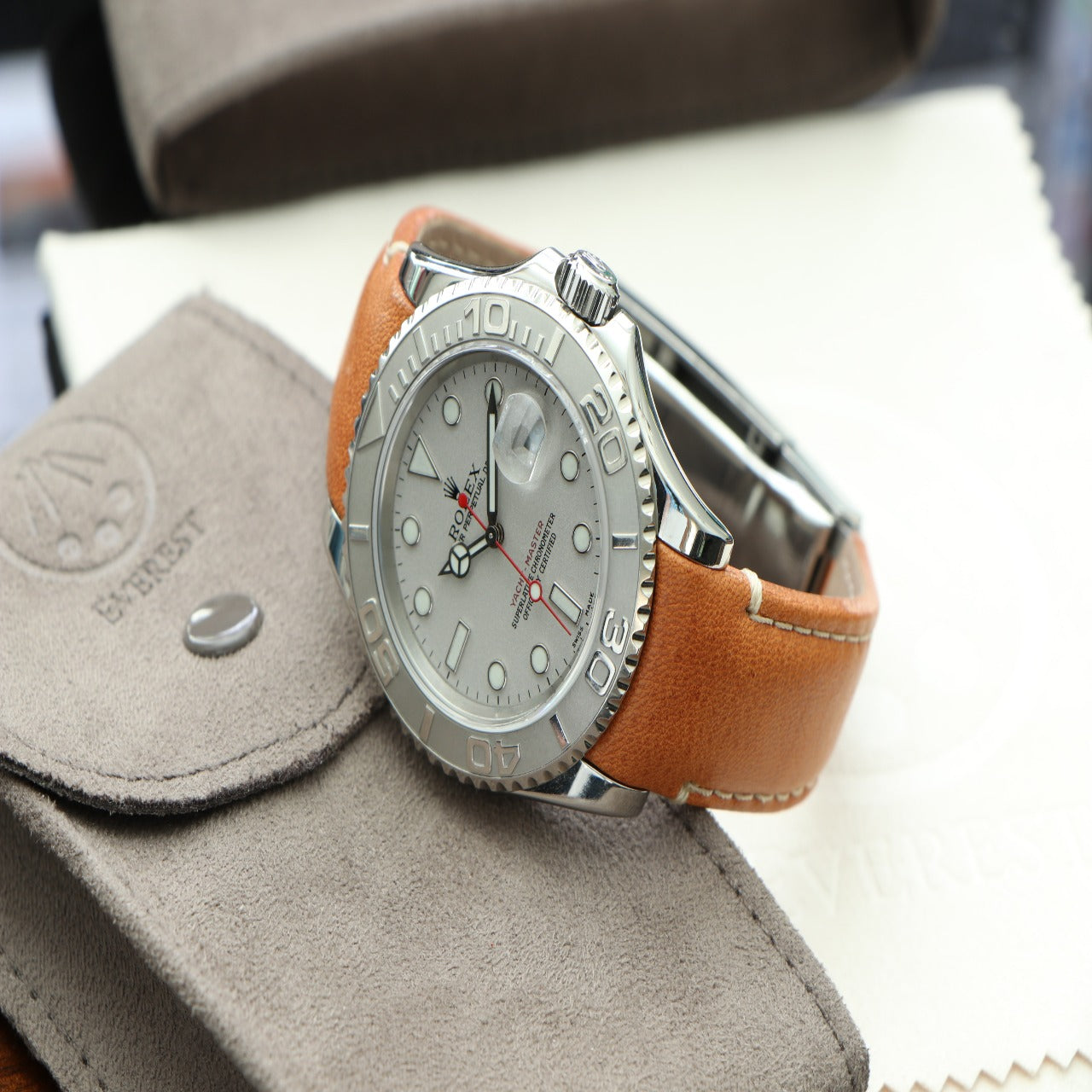 rolex yacht master watch with white dial adorning a tan curved end leather strap with deployant clasp option