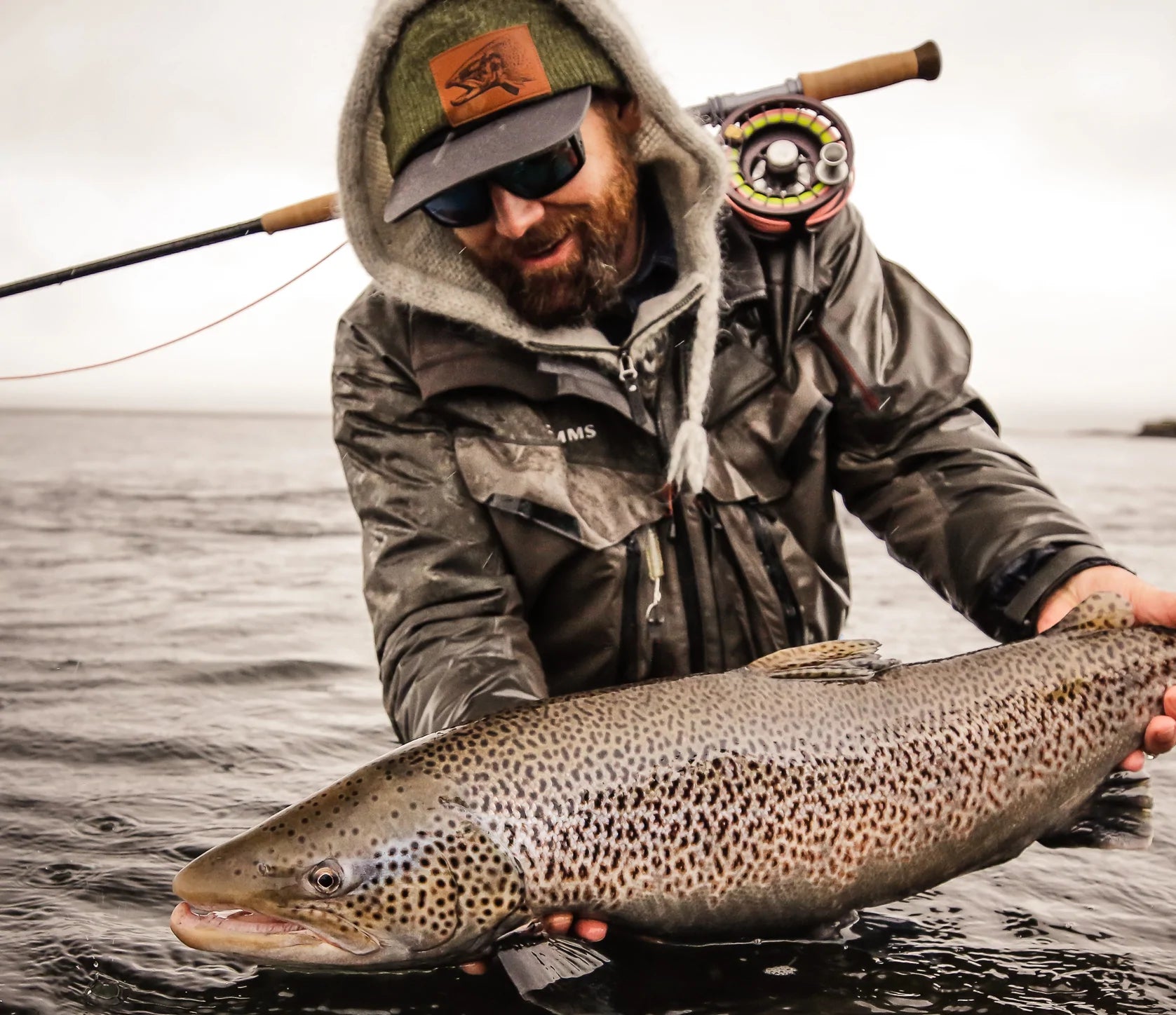 Garrison holding an Icelandic sea run brown trout over the water
