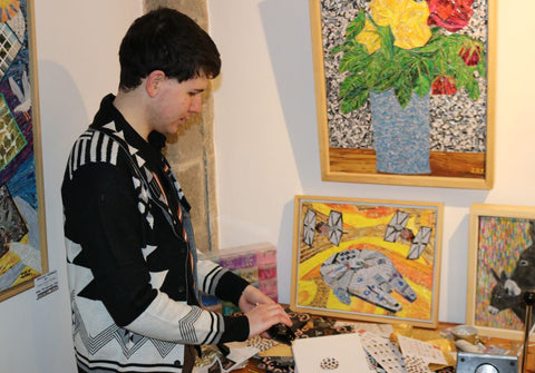 Autistic artist James Owen Thomas looking through recycled Harry Specters packaging