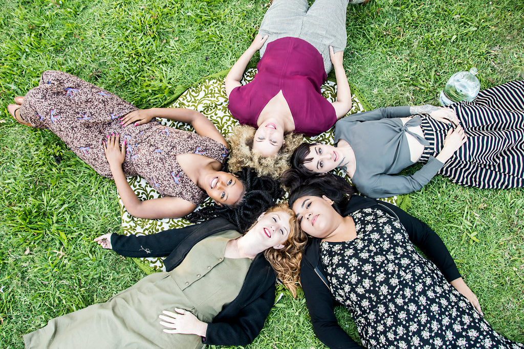 group of women laying in the grass in field days fall collection 