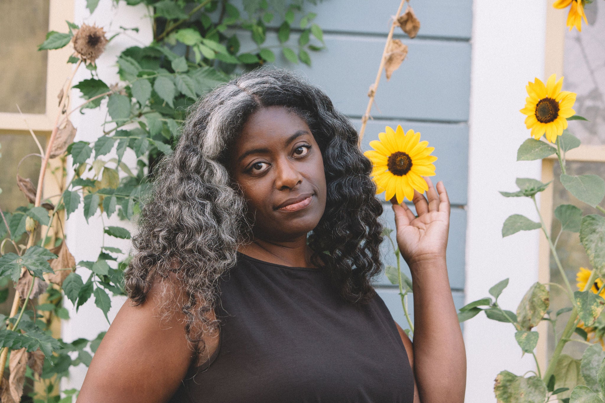 black woman in a plus size 3X brown dress with sun flower 