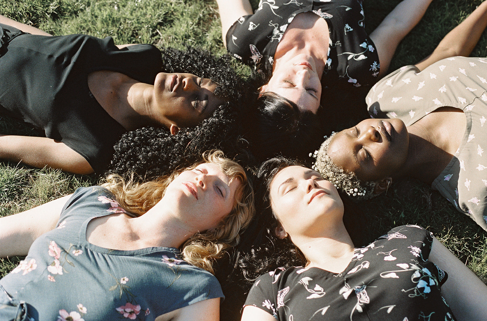 5 women with their heads touching in a circle 