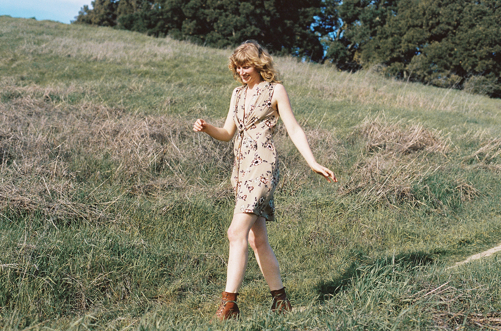 woman in tan floral dress skipping