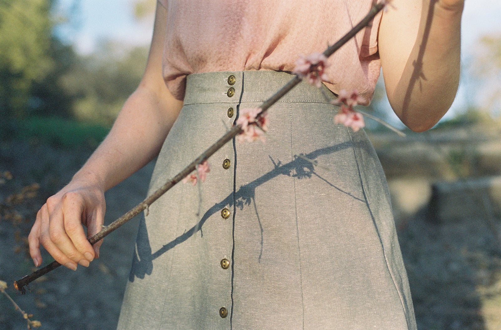 woman with pink skirt an cherry blossom branch field day apparel