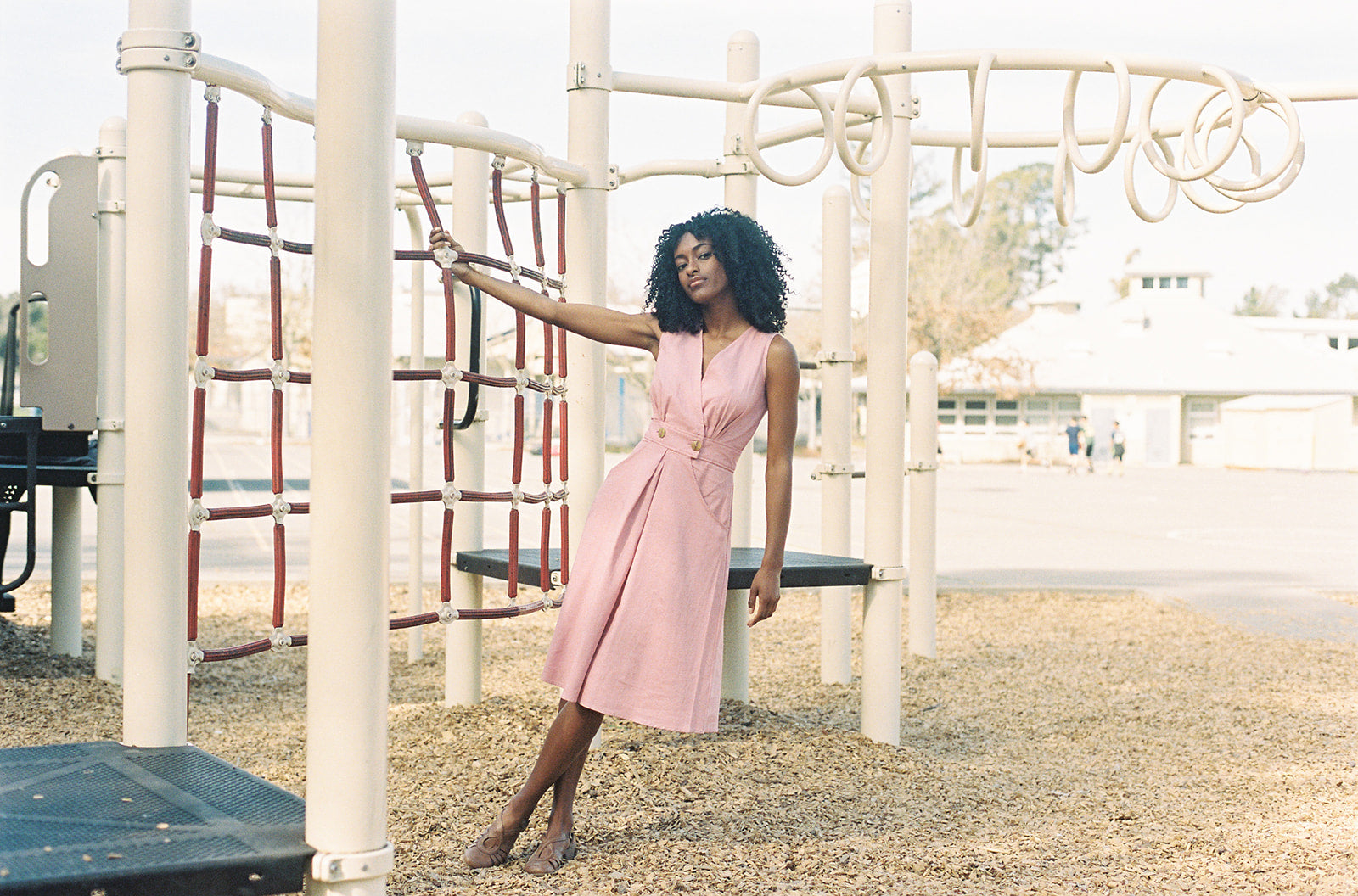 pink dress on a play ground worn by black model 
