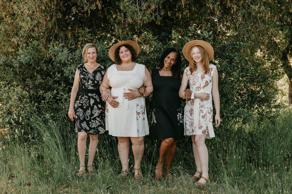 4 women wearing Field Day dresses one in black print and the the other in white print 