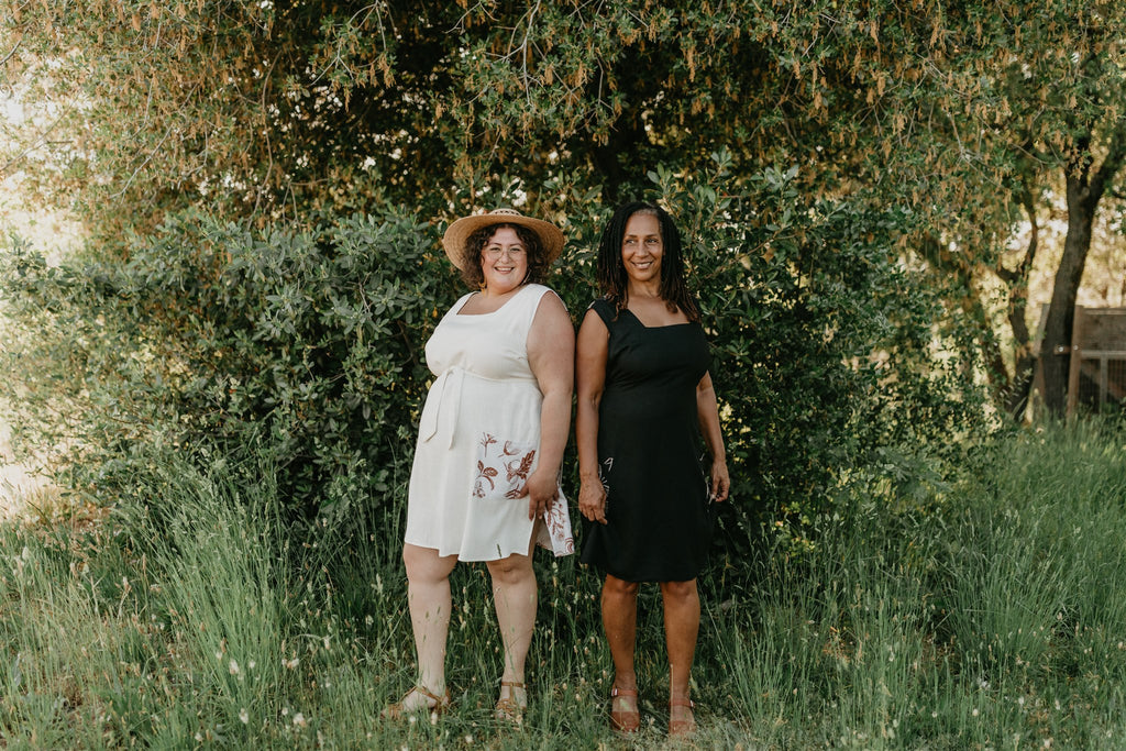 2 women wearing Field Day dresses one in black print and the the other in white print 
