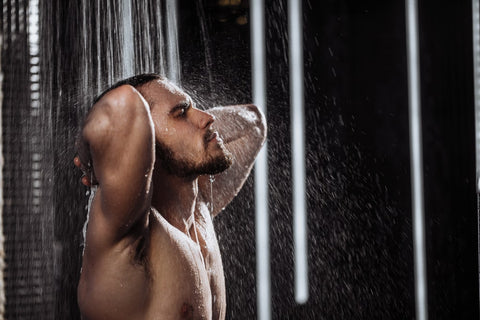 Ein junger Mann nimmt duscht sich in seiner erneuerten Dusche 