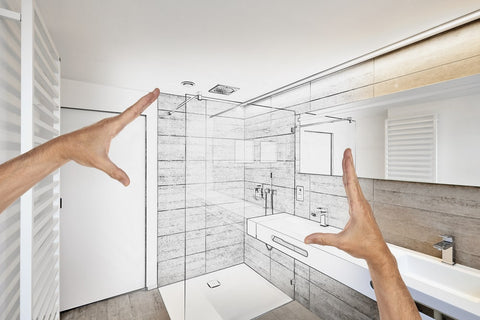 zwei Hände zeigen ein skizziertes Badezimmer