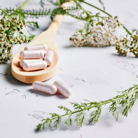 supplement capsules on a wooden spoon