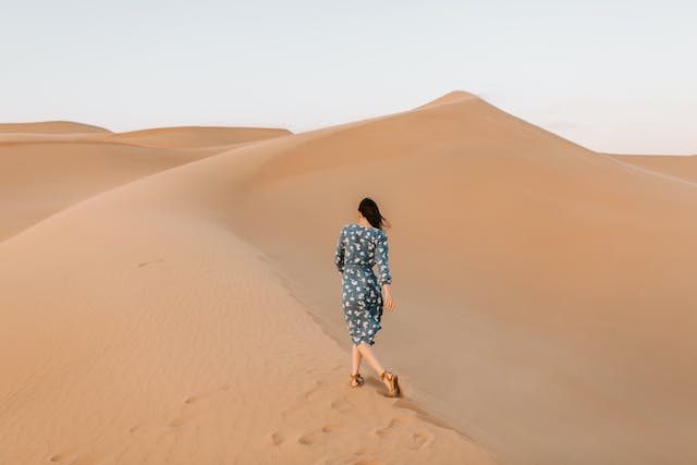 femme avec une robe marchant dans le désert
