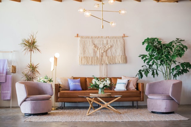 salon minimaliste avec un canapé en cuir marron et des fauteuils violet