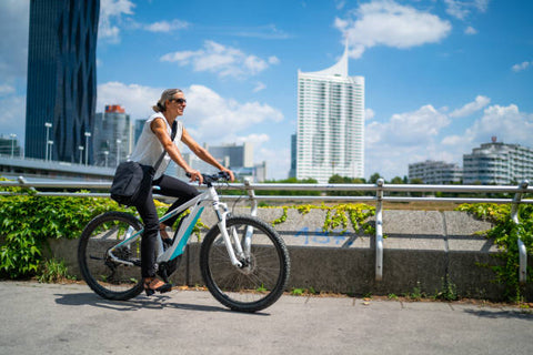 woman on electric bike riding through city