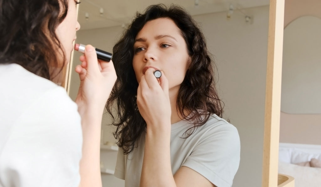 Frau, die sich Lippenpflege aufträgt.